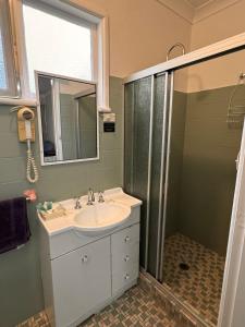 库马ALPINE COUNTRY MOTEL and METRO ROADHOUSE COOMA的一间带水槽和淋浴的浴室