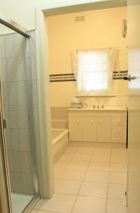 本迪戈克瑙斯度假屋的带淋浴、盥洗盆和浴缸的浴室