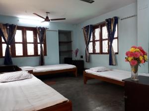 kolkataPushpak Guest House Boys, Near DumDum metro Station的带三张床和花瓶的房间