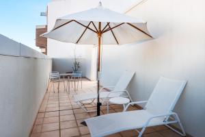 卡斯特利翁-德拉普拉纳Hotel Castellon Center Affiliated by Meliá的庭院配有白色的椅子和遮阳伞。