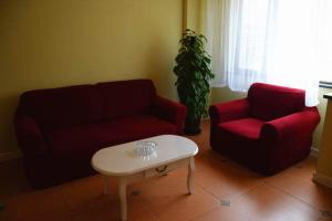 南汇如家快捷酒店上海泥城临港装备产业区店的客厅配有2张红色沙发和1张咖啡桌