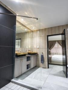 伯诺尼ANEW Hotel & Convention Centre OR Tambo Johannesburg的带淋浴的浴室和卧室