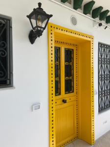 拉马萨Marsa - Sidi Bousaid Lovely Authentic Apartment的白色墙壁上的黄色门,带灯