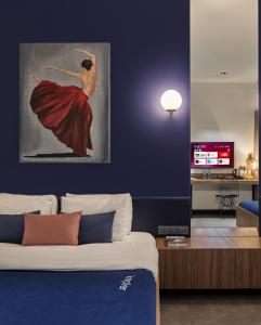 里加Kepler Club Riga Airport Hotel - Landside的卧室配有一张带女性绘画的床
