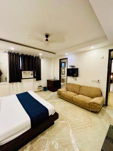 新德里Hotel The Paradise In - Near Karol Bagh Metro Station的一间卧室配有一张床和一张沙发