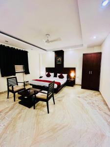 新德里Hotel The Paradise In - Near Karol Bagh Metro Station的卧室配有一张床和一张桌子及椅子