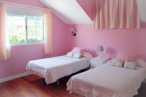 San Juan de la RamblaHoliday Home El Mar的粉红色的卧室设有两张床和窗户