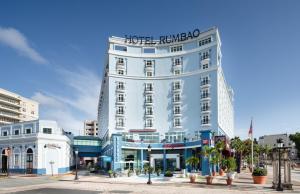 圣胡安Hotel Rumbao, a Tribute Portfolio Hotel的一座高大的白色建筑,上面有标志