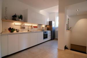 米兰伊索拉利伯拉旅馆的厨房配有白色橱柜、水槽和冰箱。