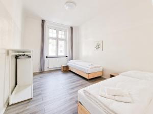 杜塞尔多夫RAJ Living - 3 Zimmer Wohnungen mit Balkon - 15 Min zur Messe DUS的白色的客房设有两张床和窗户。