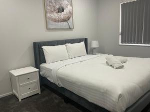 奥克兰Family Holiday Home Papakura - 175的一间卧室配有一张大床和一个床头柜