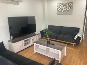 奥克兰Family Holiday Home Papakura - 175的带沙发和平面电视的客厅