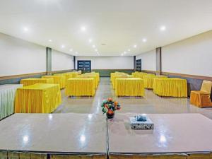 丹戎槟榔OYO 1178 PLAZA HOTEL TANJUNG PINANG的一间设有黄色桌椅的会议室