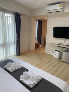 乌隆他尼Tisa Hotel Udonthani的一间卧室配有带2条白色毛巾的床