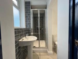 KillingworthNewly Refurbished 6 Person En-suite Apartment Tyne & Wear Newcastle Upon Tyne的一间带水槽和淋浴的浴室