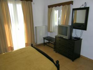 阿基奥斯基利考斯菲利皮酒店的一间卧室配有一张床,梳妆台上配有电视