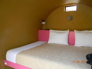 迪坡斯特兰管道宾馆的一间卧室配有一张带粉色和白色床头板的床