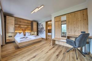 萨尔巴赫Eibinghof BED & BREAKFAST & SWIM的一间卧室配有一张床、一张桌子和一把椅子
