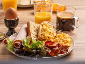 波尔多波尔多市中心圣让车站宜必思酒店的桌上的早餐食品和橙汁