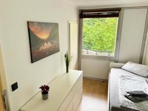 科隆Monteurwohnung in Köln-Kalk的卧室配有白色梳妆台和窗户。