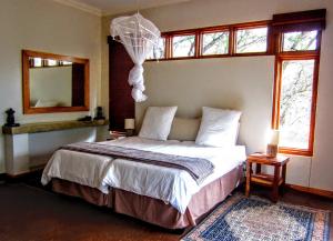 赫卢赫卢韦处碧布希度假屋的卧室配有床、镜子和窗户。