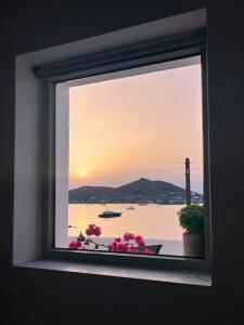 纳乌萨Linardo's Cycladic House的窗户享有大海和鲜花的景致。