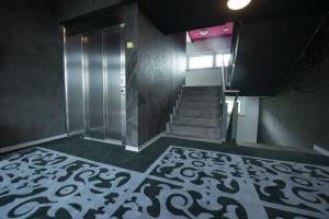 克罗伊茨林根Hotel Swiss Bellevue的大堂设有楼梯和带玻璃门的电梯