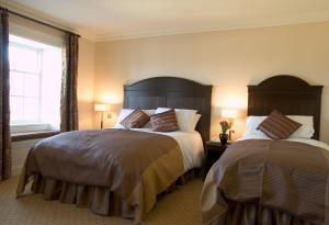卡舍尔卡什尔百利酒店的一间卧室设有两张床和窗户。