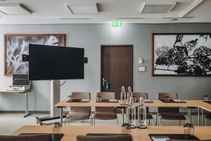 卢塞恩AMERON Luzern Hotel Flora的客房设有桌椅和平面电视。