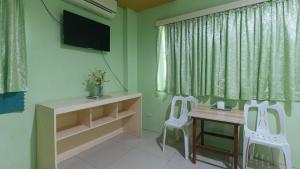 CabatuanCM Apartelle Iloilo International Airport by RedDoorz的一间设有两把椅子、一张桌子和一台电视的房间