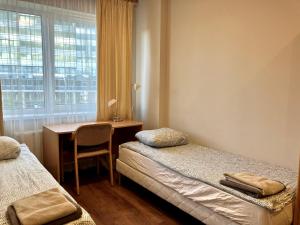 里加RVR Smart Apartments Riga with self Check-in的客房设有两张床、一张桌子和一个窗户。