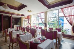 阿加迪尔利亚布公寓酒店的餐厅设有白色的桌椅和窗户。