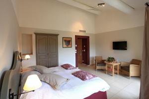 拉莫特Le Domaine de Saint Endreol Golf & Spa Resort的一间带大床的卧室和一间客厅