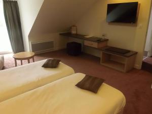 茹瓦尼左岸餐厅酒店的酒店客房设有两张床和一台平面电视。