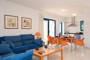 普拉亚布兰卡拉斯码头别墅酒店的客厅配有蓝色的沙发和桌子