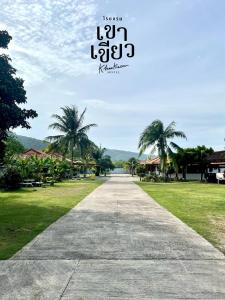 KHAO KIEOW Hotel โรงแรมเขาเขียว的一条种有棕榈树的走道