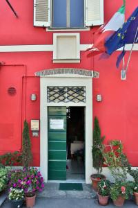 卢卡德拉罗萨阿菲卡梅瑞酒店的一座红色的建筑,有绿门和鲜花