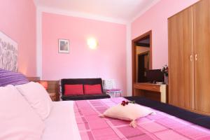 卢卡德拉罗萨阿菲卡梅瑞酒店的卧室设有粉红色的墙壁、一张床和椅子