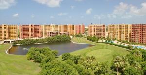 阿莱曼Golf Porto Marina El alamein North Coast جولف بورتو مارينا的享有带池塘和建筑的度假村的空中景致