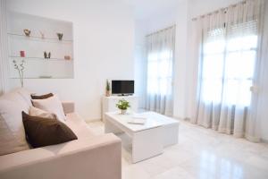 塞维利亚玛卡莲娜公寓的白色的客厅配有白色的沙发和电视