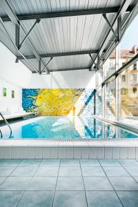 格拉茨Augarten Art Hotel, a Member of Design Hotels的一座建筑的一侧,设有一座带壁画的游泳池