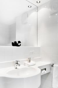 格拉茨奥加唐艺术酒店的白色的浴室设有水槽和镜子