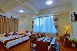 曼德勒79号生活酒店的酒店客房设有两张床、一张沙发和一张桌子。