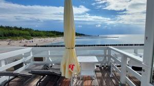 尤斯托尼莫斯基Pokoje na plaży的海滩上带遮阳伞的阳台