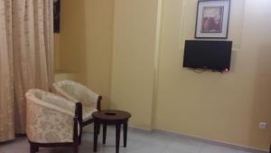 阿尔布亚米阿里亚那酒店的客厅配有电视、椅子和桌子