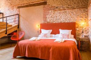 佩皮尼昂马斯拉图尔纳维尔酒店的一间卧室配有一张带红色毯子的大床