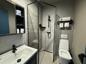 奥拉涅斯塔德Central Boutique Hotel的带淋浴、卫生间和盥洗盆的浴室