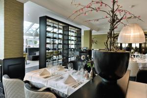 拿撒勒拿撒勒 - 根特凡德瓦克酒店的一间用餐室,配有一张桌子和植物