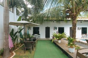 邦劳RedDoorz Plus at Palm Rise K Diving Resort Panglao Bohol的房屋内带绿色地板的庭院