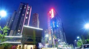 贵阳Echarm Hotel Guiyang Xiaohe Huanghe Road的一座城市在晚上点燃,有高楼